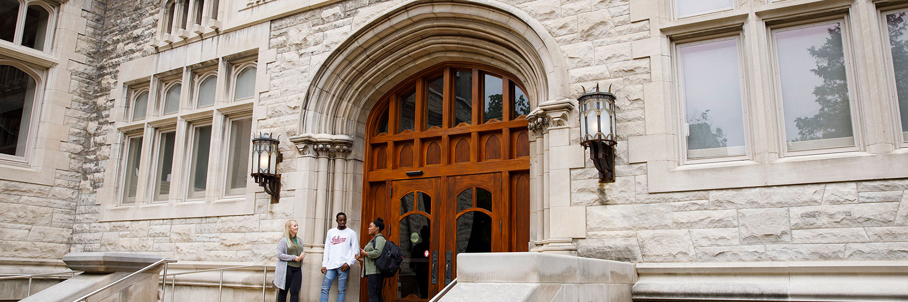 Three students stand in front of Franklin Hall.